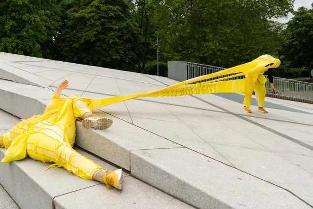 Persons in yellow costume in art performance