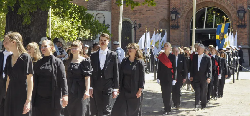 A train of black clothed people.