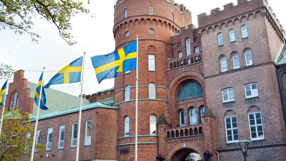 Foto på AF-borgen, en stor borgliknande byggnad i Lund. Svenska flaggan vajar.