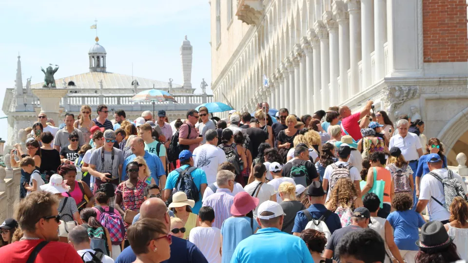Foto som visar Dogepalatset i Venedig packat med folk utanför.