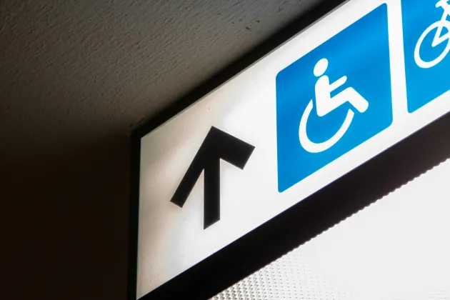 Foto på en upplyst skylt med en rullstolsikon.