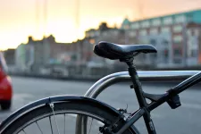 Foto av närbild på en cykelsadel med en stad i bakgrunden.