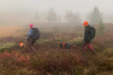 Två jägare med hund i svensk skog.