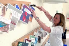 Pernilla Danielsson spikar upp en bok på en vägg.