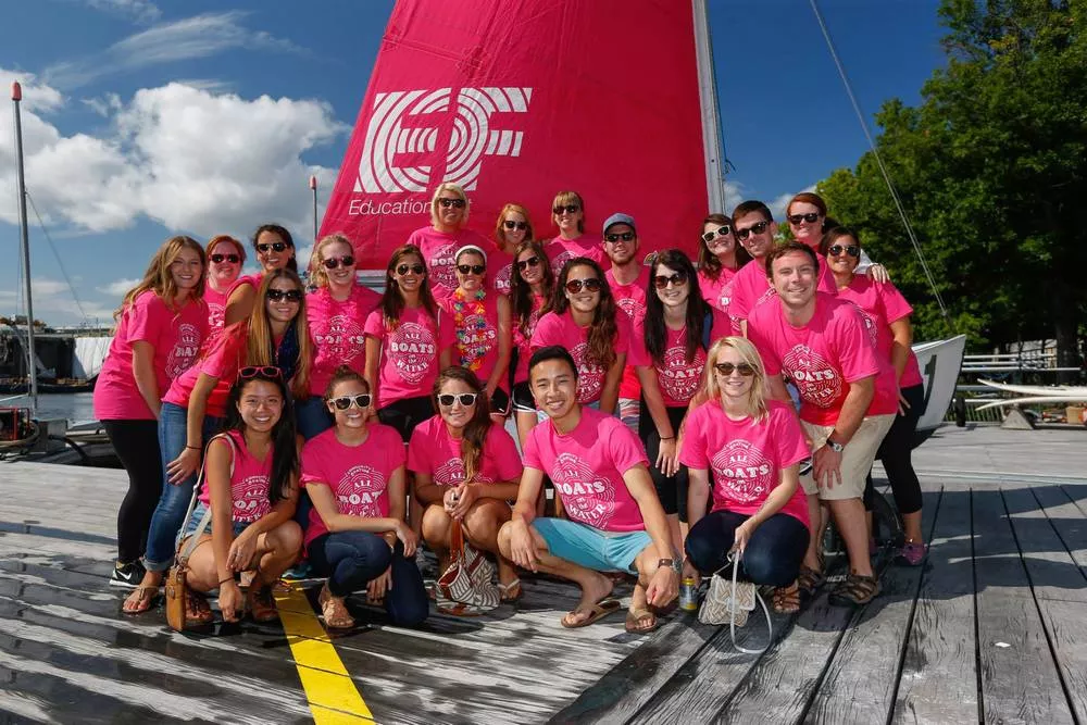 En stor grupp med människor som alla har på sig rosa EF-tröjor.