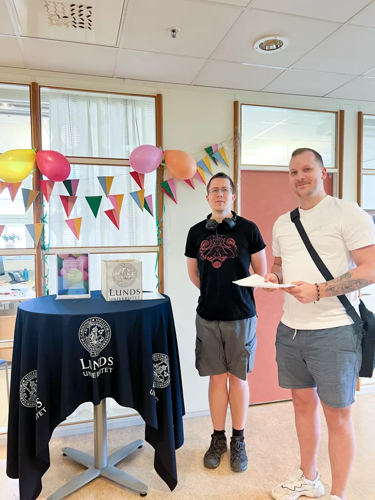 Två studenter med sin uppsats.